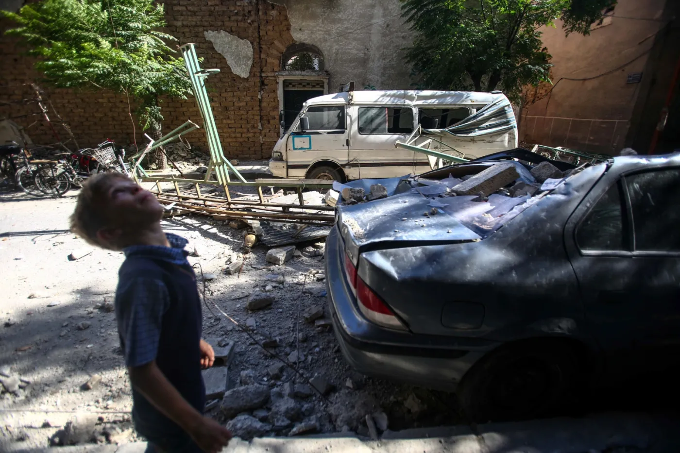 Chłopiec na tle zniszczonej Doumy w Syrii