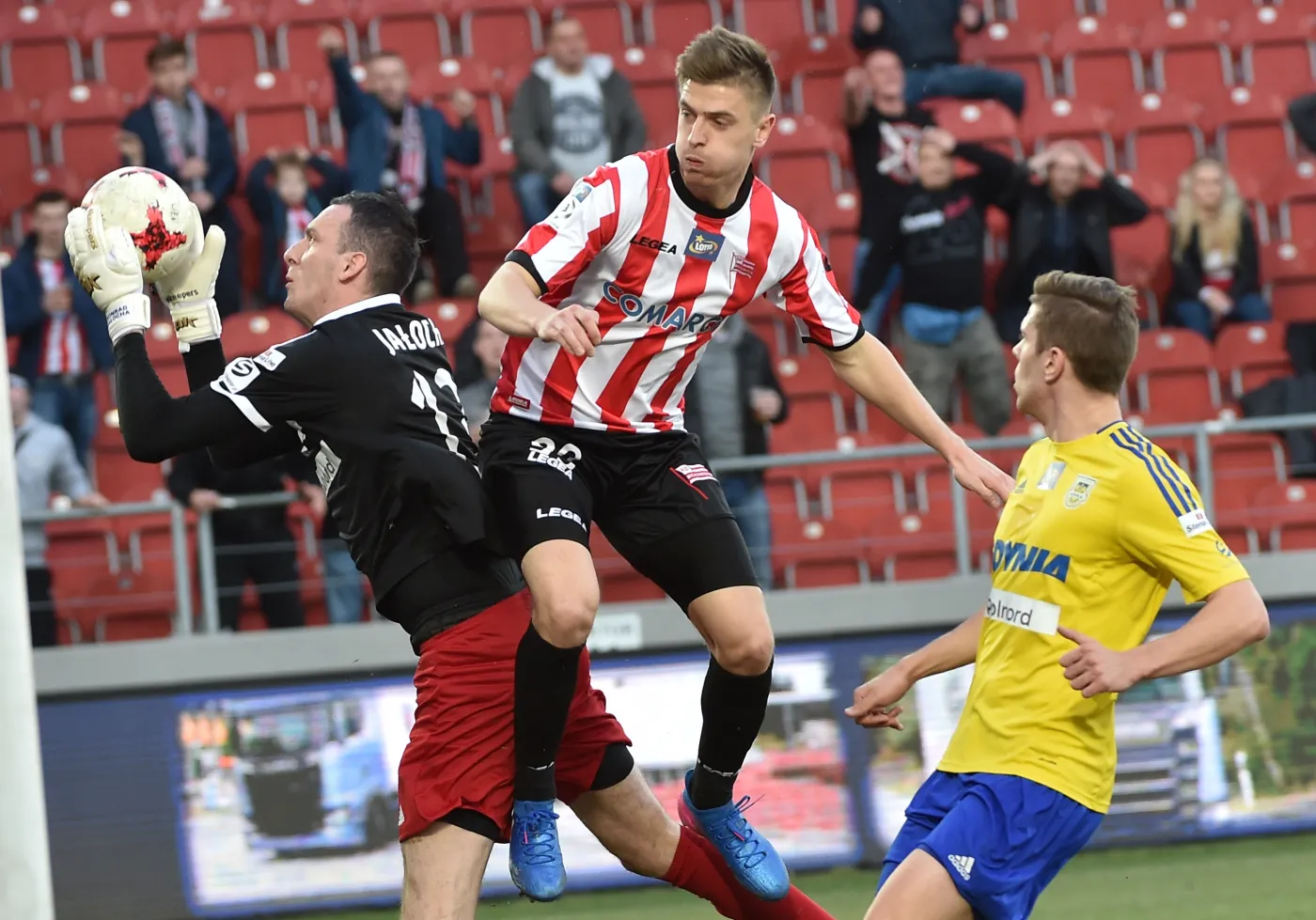 Zawodnik Cracovii Krzysztof Piątek (C) oraz bramkarz Arki Gdynia Konrad Jałocha (L) i Michał Marcjanik (P) 