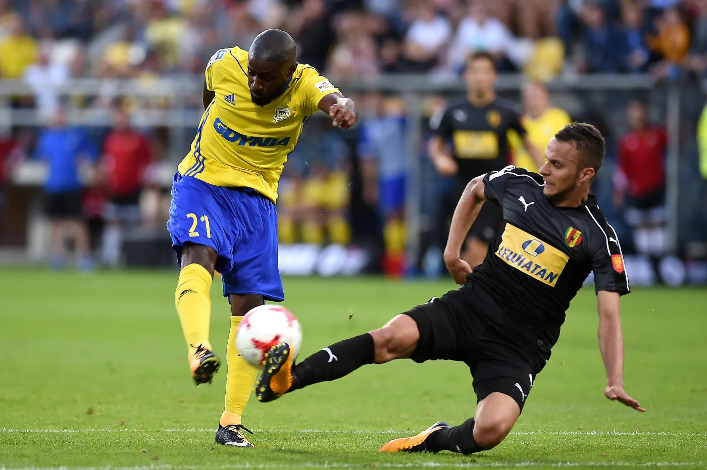 Piłkarz Arki Gdynia Yannick Sambea (L) i Marcin Cebula (P) z Korony Kielce