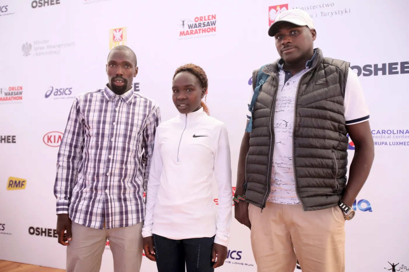 Trzykrotny zwycięzca ORLEN Warsaw Marathon (2015, 2016, 2018), Kenijczyk Ezekiel Omullo (L) i debiutująca na trasie 42 km i 195 metrów Kenijka Antonina Kwambai (C) podczas konferencji prasowej