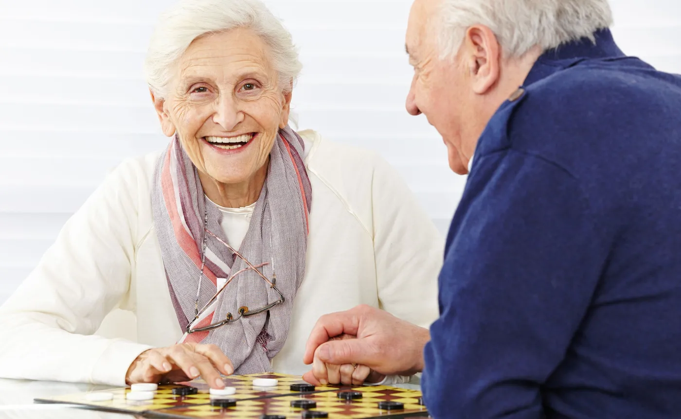 Starsza kobieta i starszy mężczyzna grają w szachy