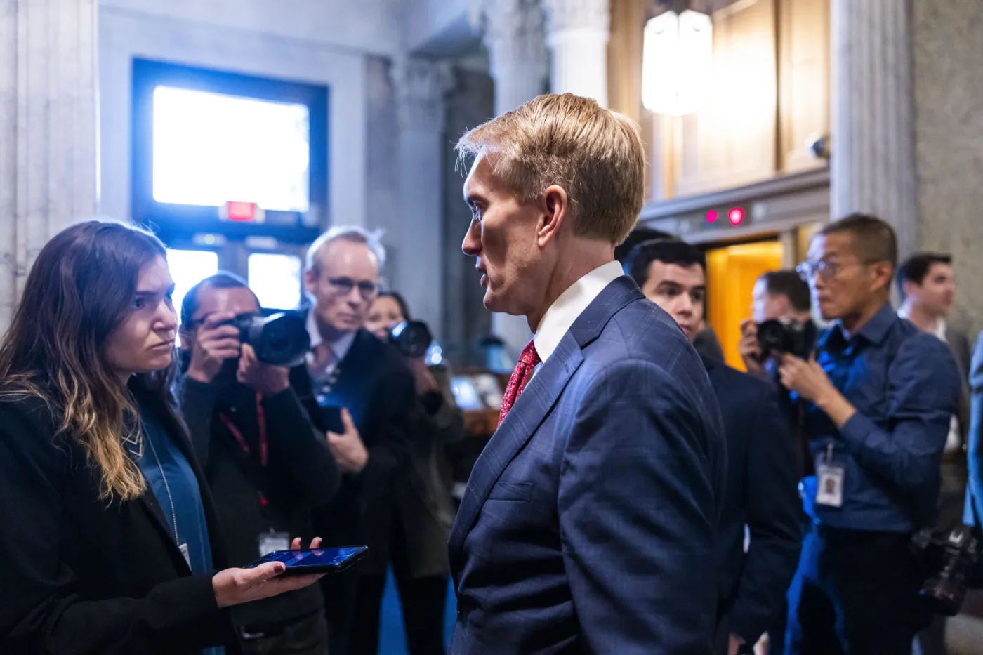 Republikański senator z Oklahomy James Lankford (w środku) rozmawia z reporterami 