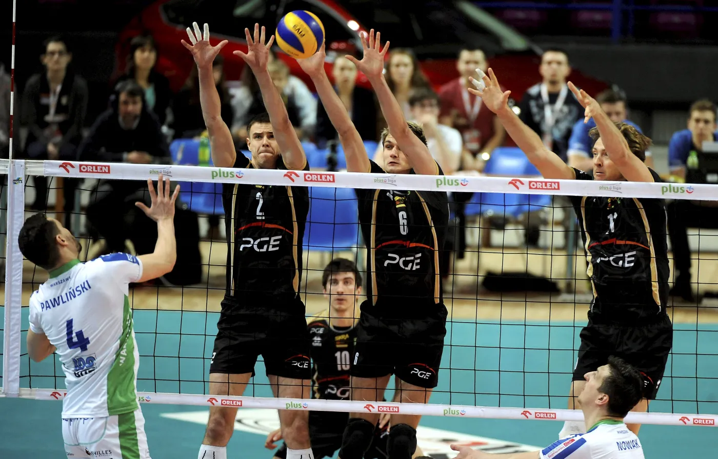 Zawodnik AZS Politechniki Warszawskiej Maciej Pawliński (L) atakuje po bloku Mariusza Wlazłego (2L), Karola Kłosa (3L) i Stephane Antigi (P) z PGE Skra Bełchatów podczas trzeciego meczu ćwierćfinałowego