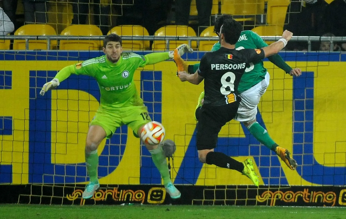 Bramkarz Legii Warszawa Dusan Kuciak (L) z pomocą Guilherme (P) bronią się przed atakiem Koena Persoons'a (C) z KSC Lokeren