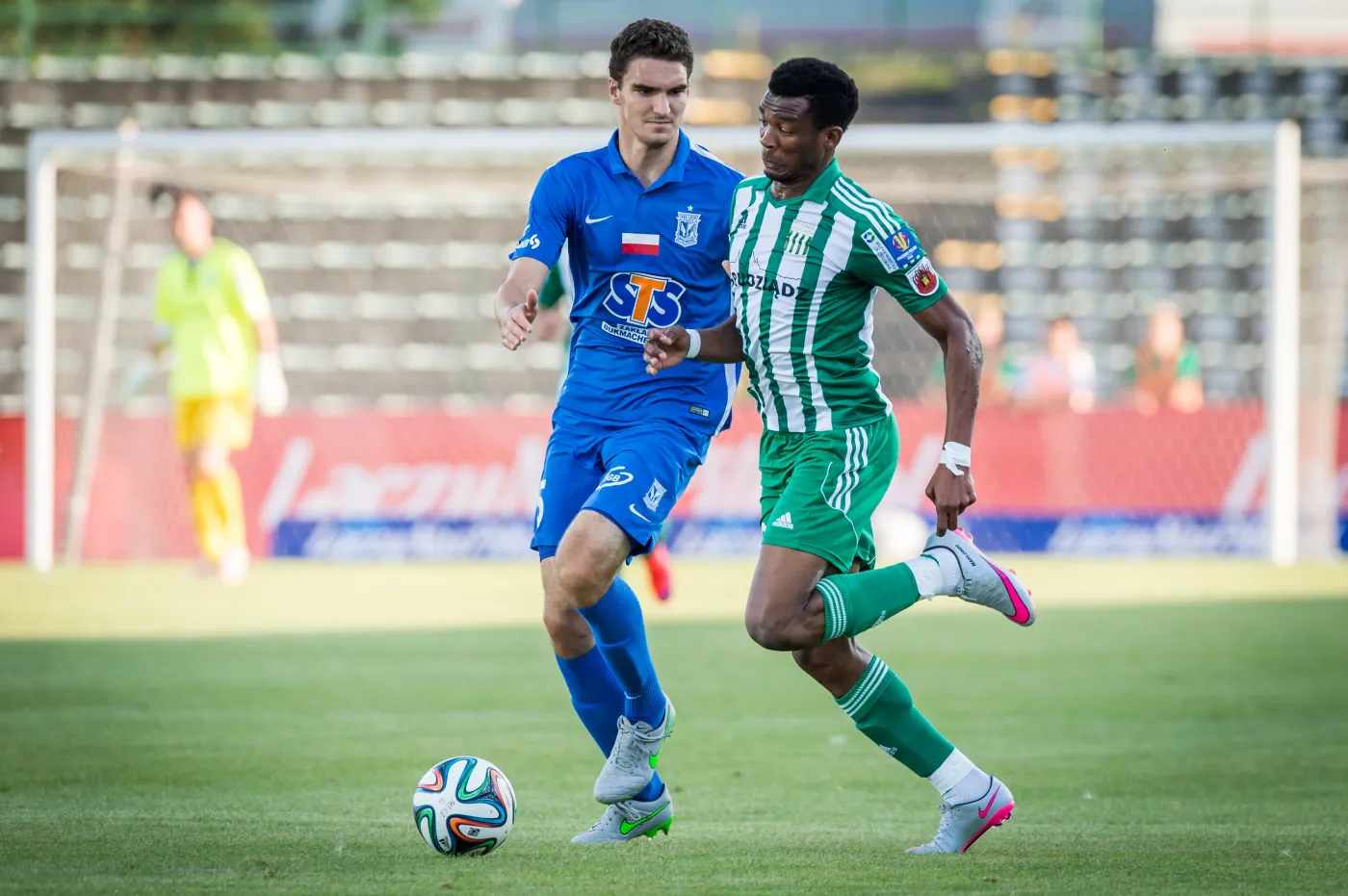 Zawodnik Lecha Poznań Marcin Kamiński (L) walczy o piłkę z Donaldem Djousse (P) z Olimpii Grudziądz podczas meczu 1/16 finału Pucharu Polski