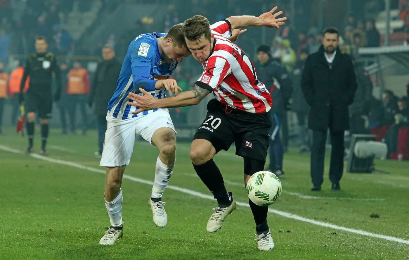 Zawodnik Cracovii Mateusz Szczepaniak (P) i Tomasz Kędziora (L) z Lecha Poznań