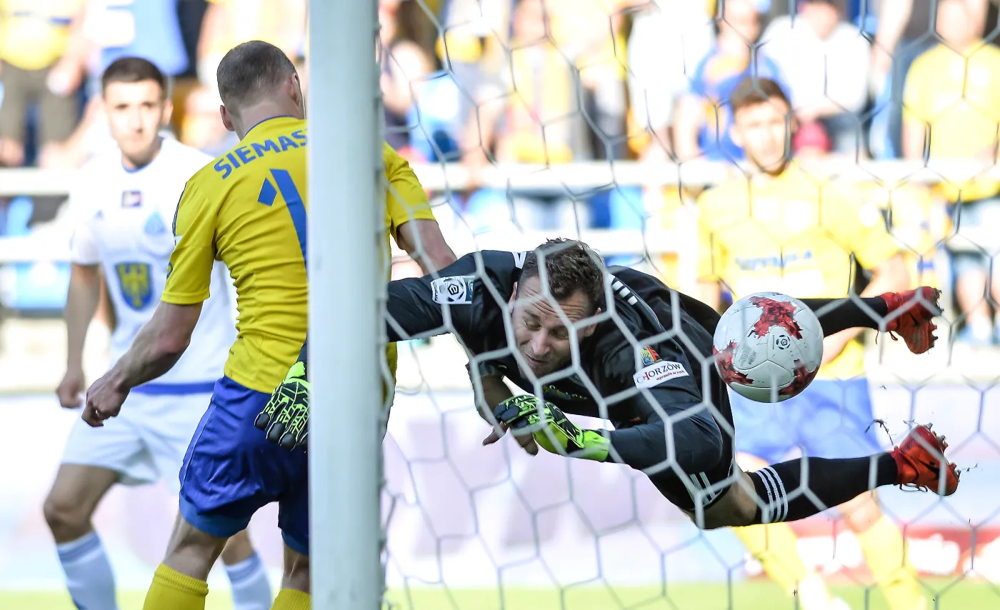 Zawodnik Arki Gdynia Rafał Siemaszko (L) zdobywa wyrównującego gola. Bramki Ruchu Chorzów broni Libor Hrdlićka (P) 