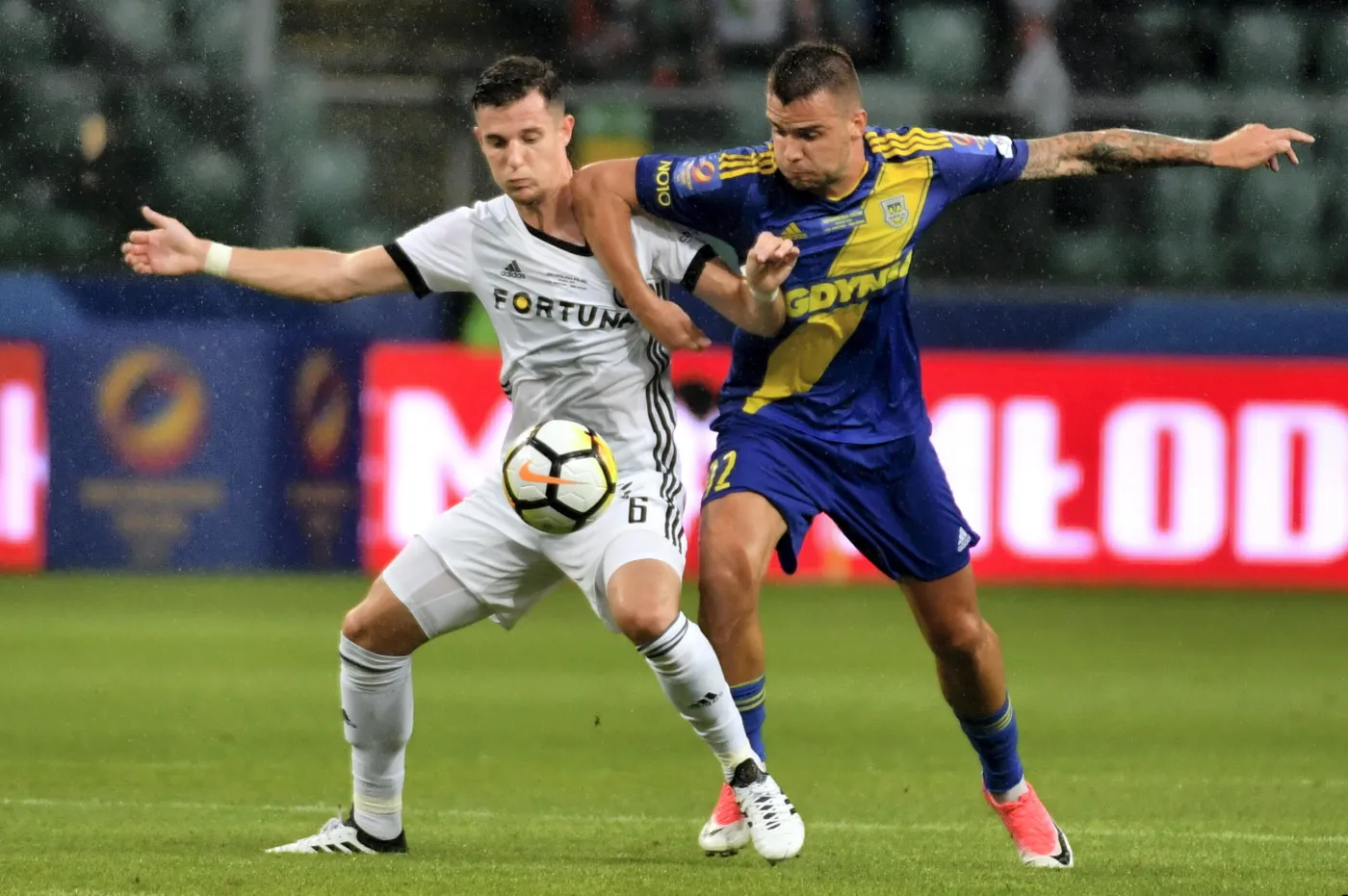 Piłkarz Legii Warszawa Chris Philipps (L) i Aleksandar Kolev (P) z Arki Gdynia