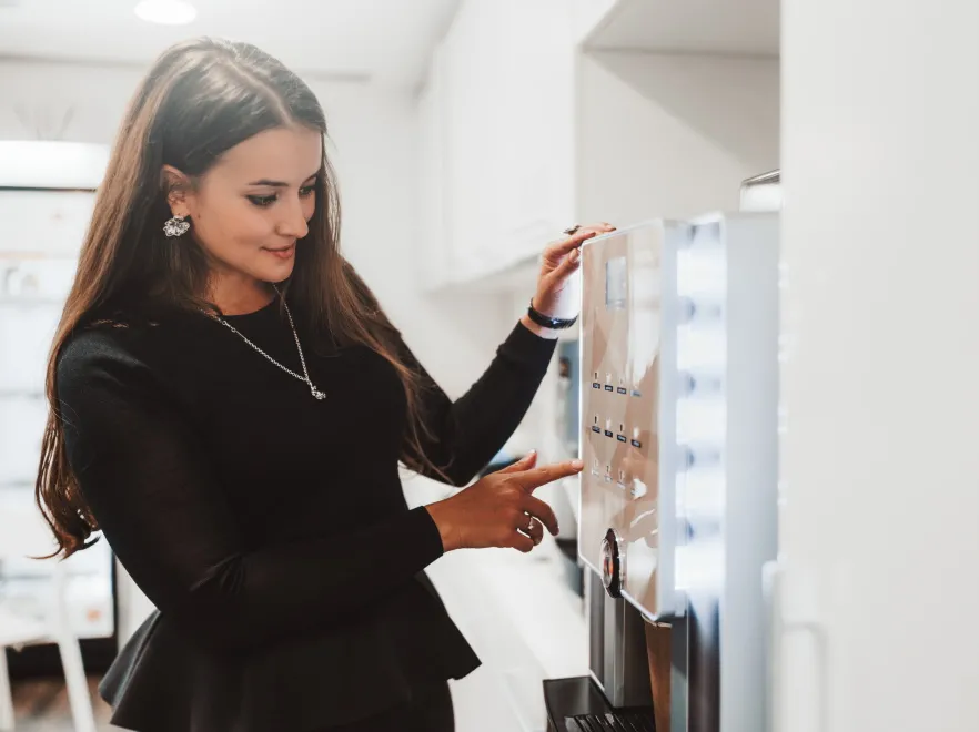Kobieta zamawia kawę. Automat do kawy