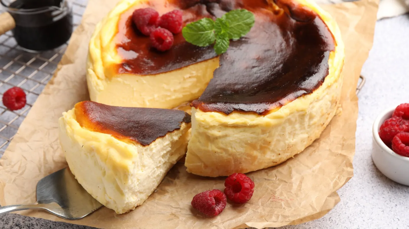 Tasty,Basque,Cheesecake,With,Raspberries,And,Mint,On,Light,Grey