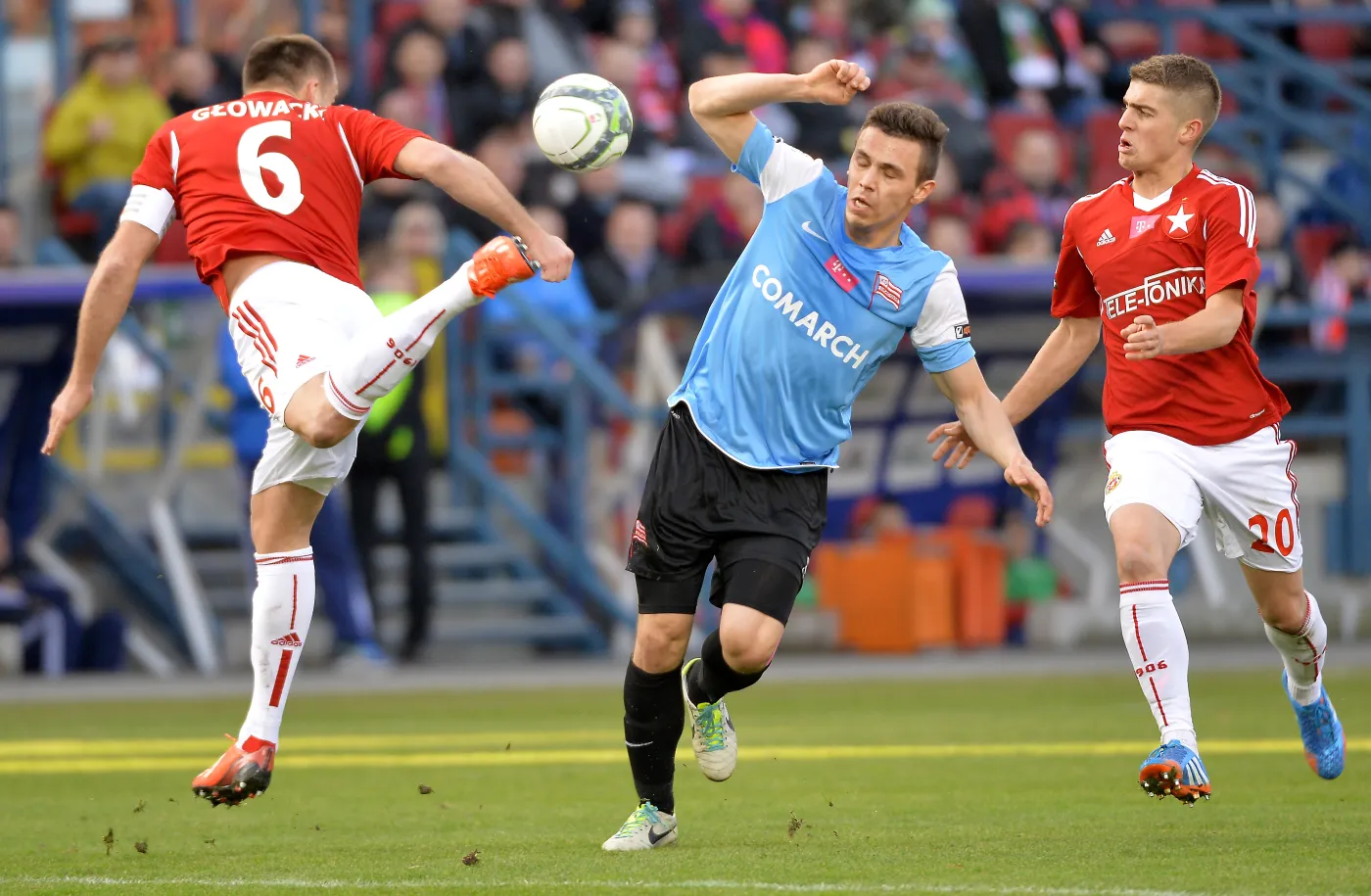 Zawodnik Cracovii Krzysztof Danielewicz (C) walczy o piłkę z Arkadiuszem Głowackim (L) i Michałem Chrapkiem (P) z Wisły podczas meczu polskiej Ekstraklasy