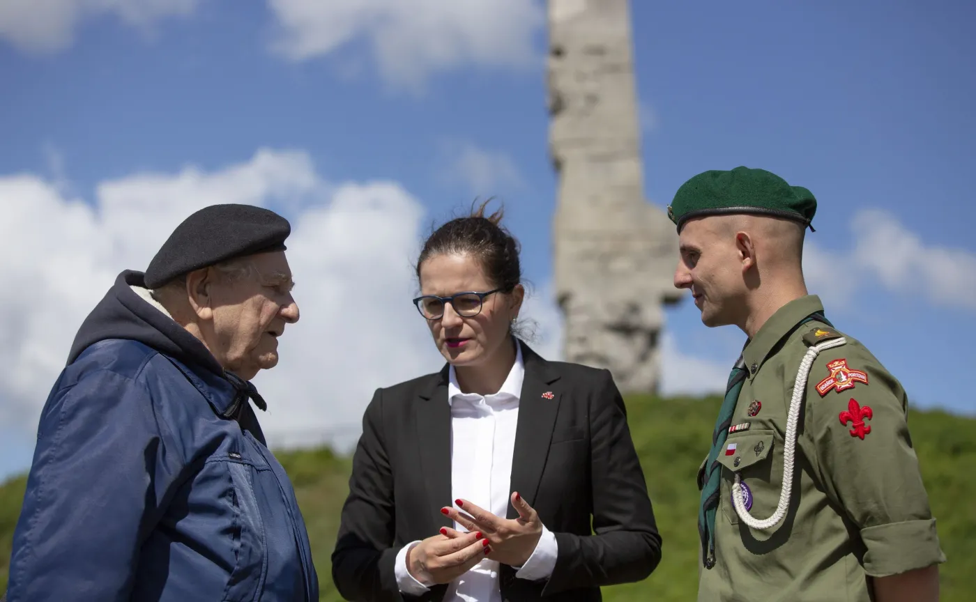 Prezydent miasta Aleksandra Dulkiewicz (C) oraz kombatant kpt. Henryk Bajduszewski (L) i harcmistrz Artur Lemański (P) podczas konferencji prasowej, 5 bm. u stóp kopca pomnika Obrońców Wybrzeża po przyjęciu przez Sejm 4 bm. specustawy ws. Westerplatte