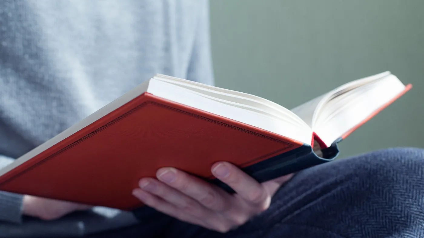 Open,A,Thick,Book,In,His,Hands,Close,Up