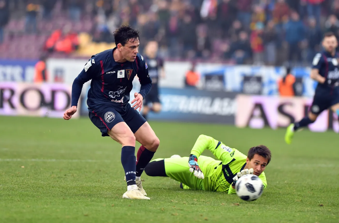 Zawodnik Pogoni Szczecin Iker Guarrotxena (L) pokonuje bramkarza Miedzi Legnica Antona Kanibolotskyi (P)