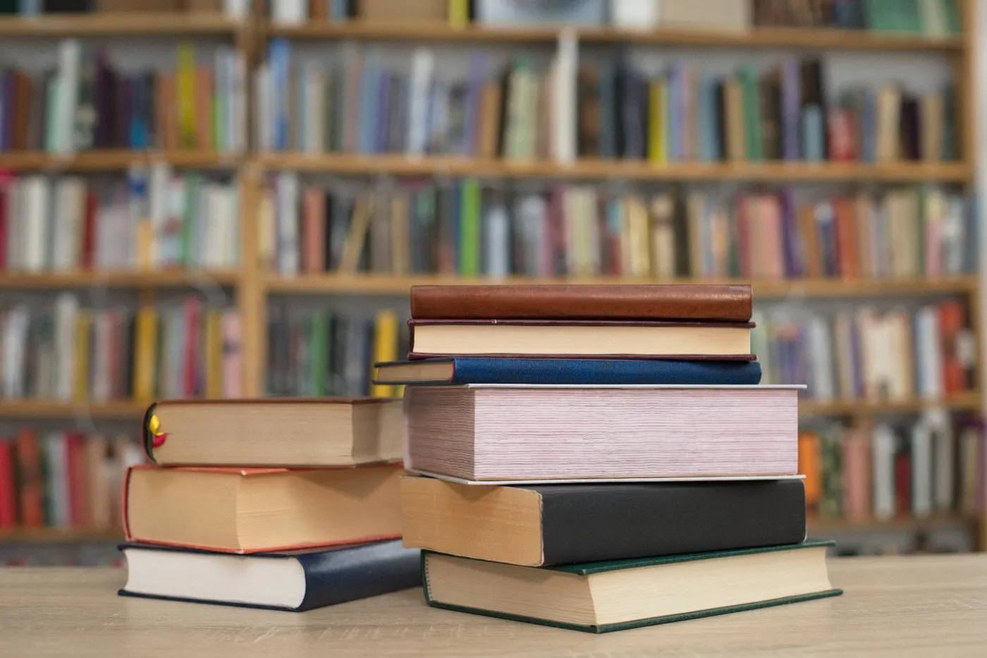 Stack,Of,Books,On,Wooden,Table,In,Library,,In,The