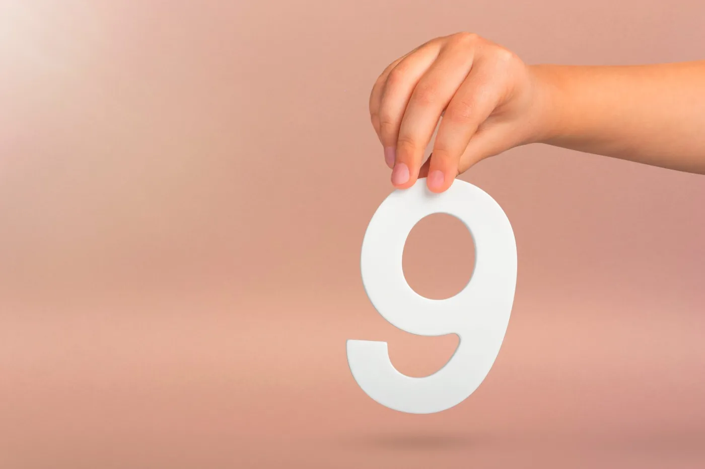 Number,Nine,In,Hand.,A,Hand,Holds,A,White,Number