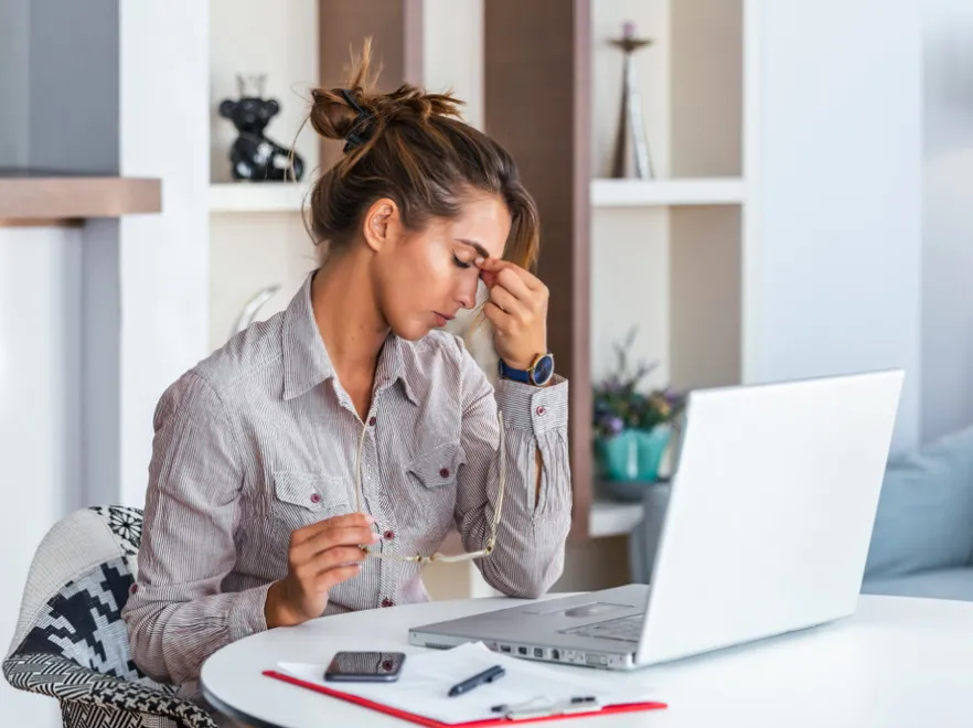 Kobieta przy komputerze. Zmęczenie. Ból głowy. Migrena
