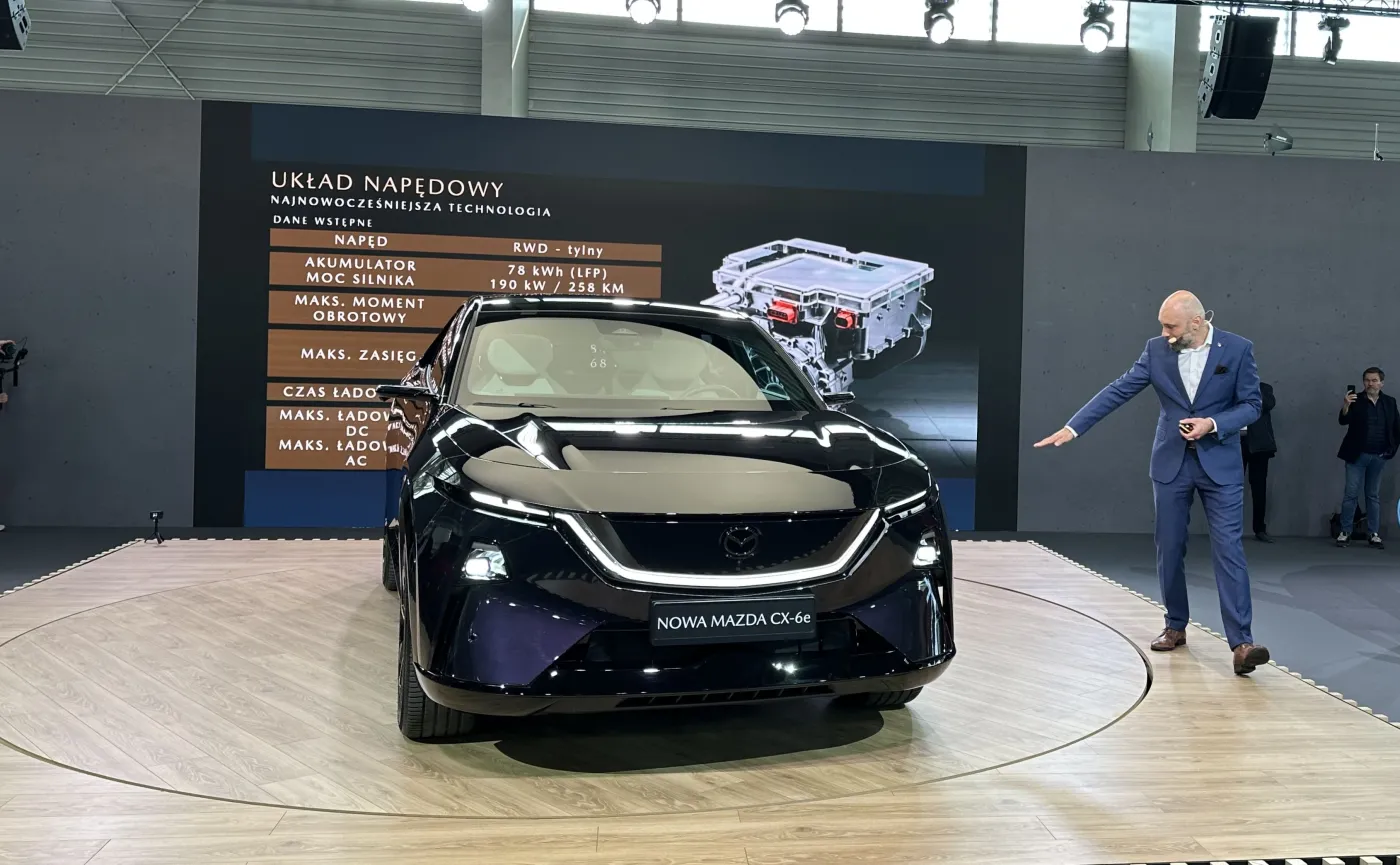 Przód nowej Mazdy CX-6e w kolorze fioletowym, z bliska widoczne nowoczesne reflektory LED i podświetlany grill, premiera Poznań Motor Show