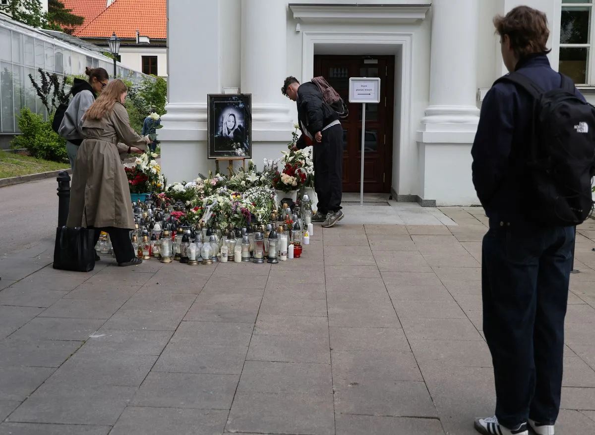 Znicze pod zdjęciem zabitej kobiety, przed budynkiem Auditorium Maximum Uniwersytetu Warszawskiego