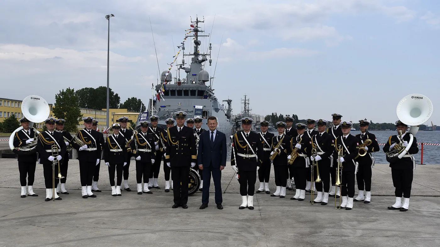 Mariusz Błaszczak na tle niszczyciela min typu Kormoran II