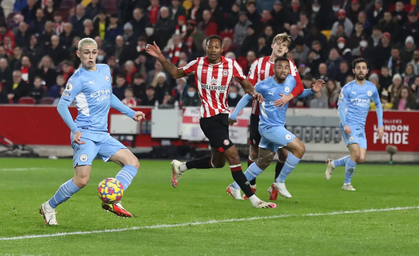 Piłkarz Manchesteru City Phil Foden (L) strzela gola Brentfordowi