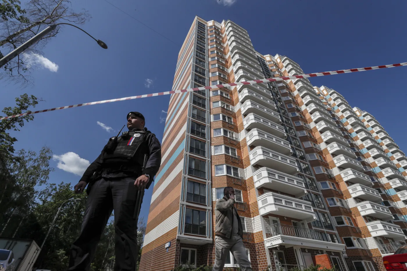 Moskwa. Policjant zabezpiecza teren w pobliżu zniszczonych budynków