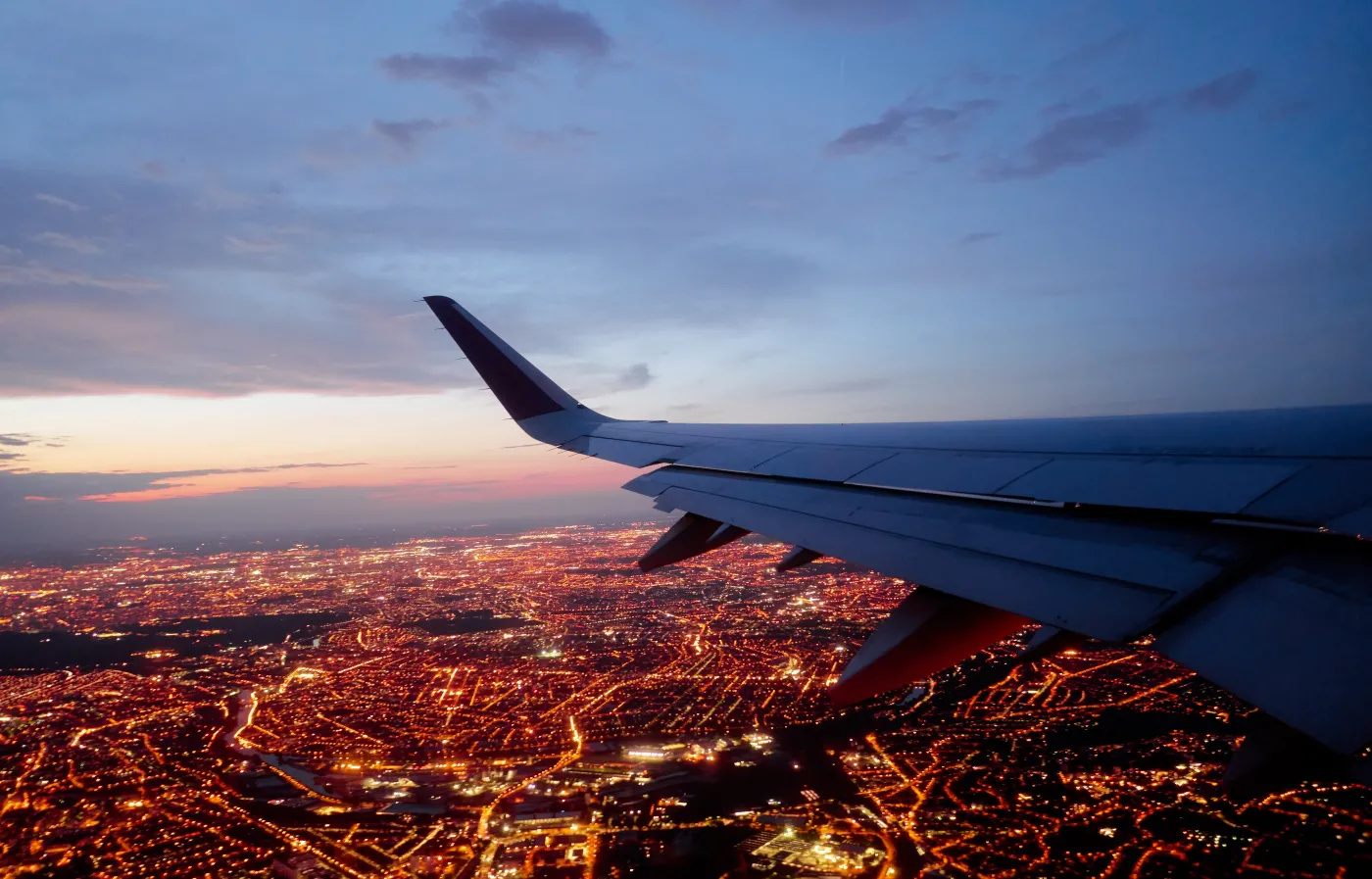 Wing,Of,Modern,Aircraft,Flying,Above,Paris,At,Night
