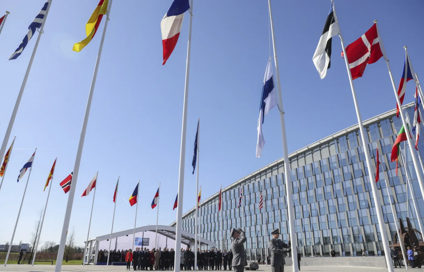 Flaga Finlandii wciągana na maszt przed kwaterą główną NATO w Brukseli