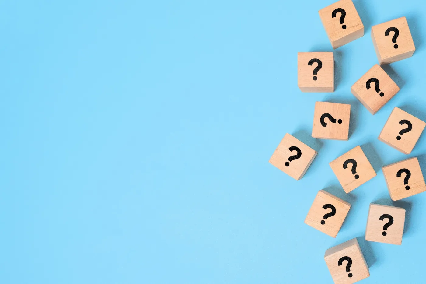 Many,Question,Mark,Signs,On,Wood,Blocks,On,Blue,Paper