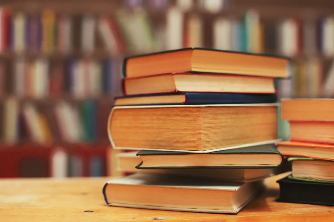 Stack,Of,Books,On,Wooden,Table,In,Library.,Space,For