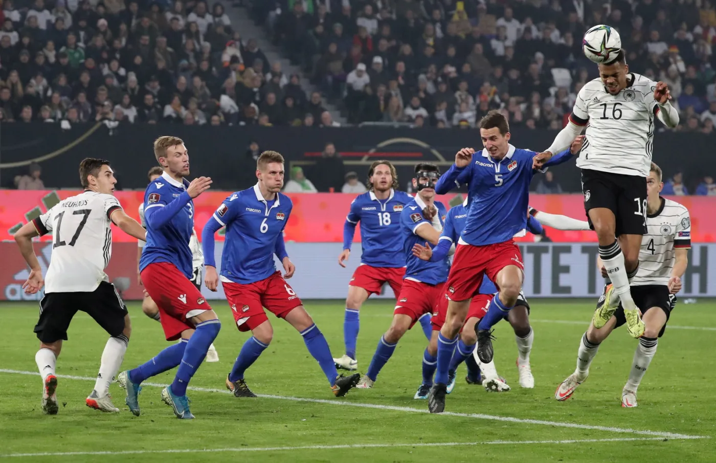 Niemiec Lukas Nmecha (P) i Liechtensteińczyk Rafael Grunenfelder (2-R) podczas meczu el. MŚ 2022