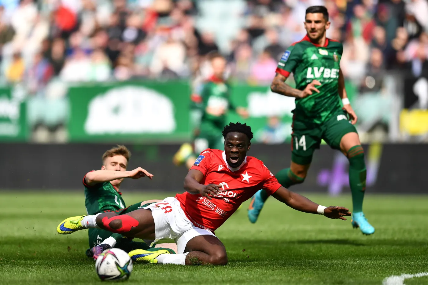 Piłkarz Śląska Wrocław Łukasz Bejger (L) i Elvis Manu (C) z Wisły Kraków podczas meczu Ekstraklasy
