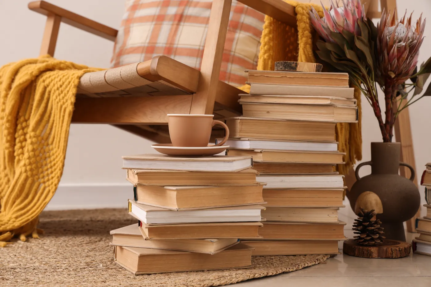 Stacks,Of,Books,With,Tea,Cup,Near,Armchair,In,Room
