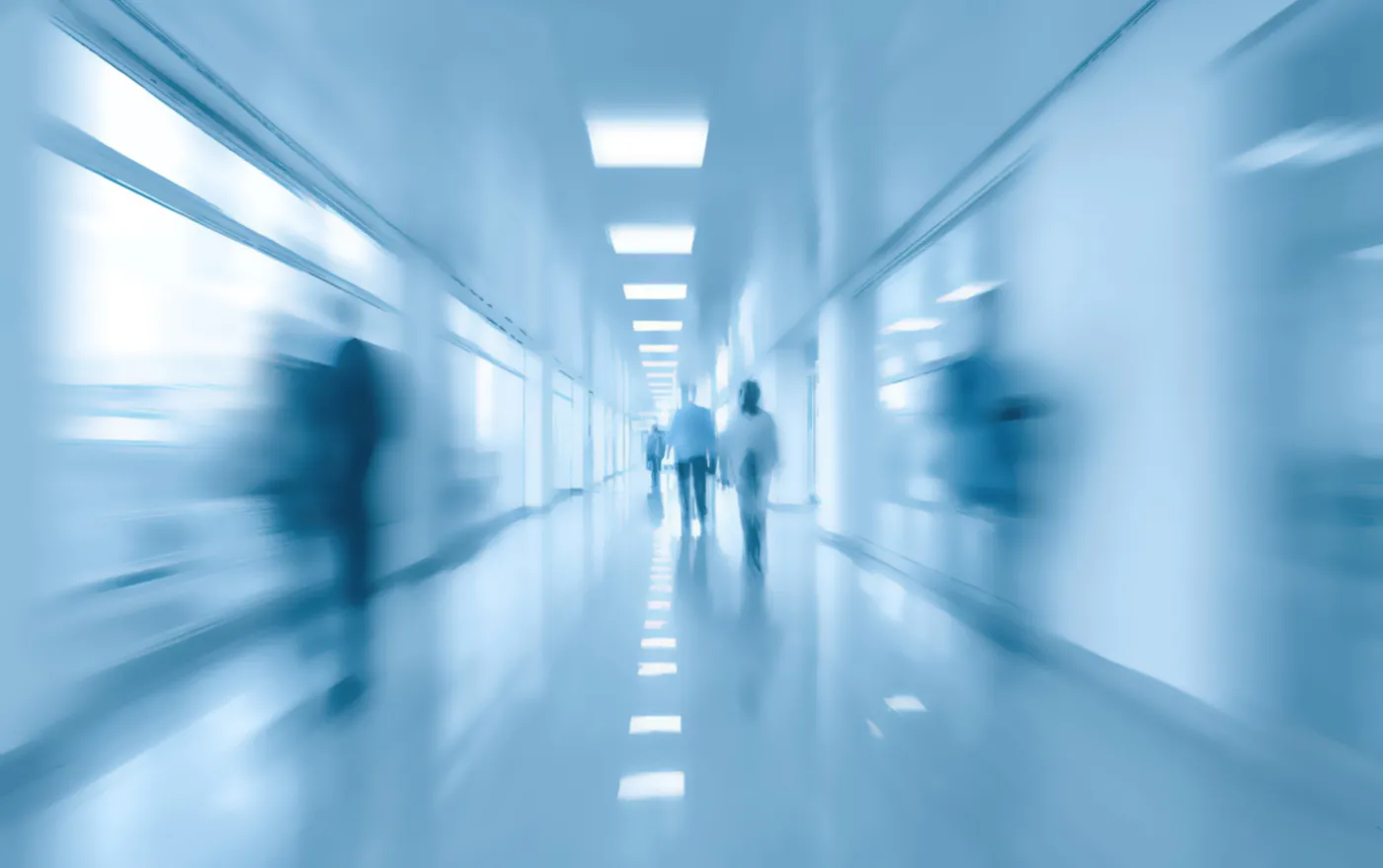 Motion,Blur,Effect,On,People,Walking,In,A,Sterile,,Blue-toned