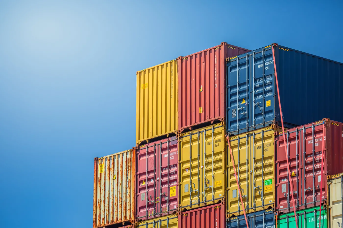Stacked,Colorful,Shipping,Containers,Against,A,Clear,Blue,Sky
