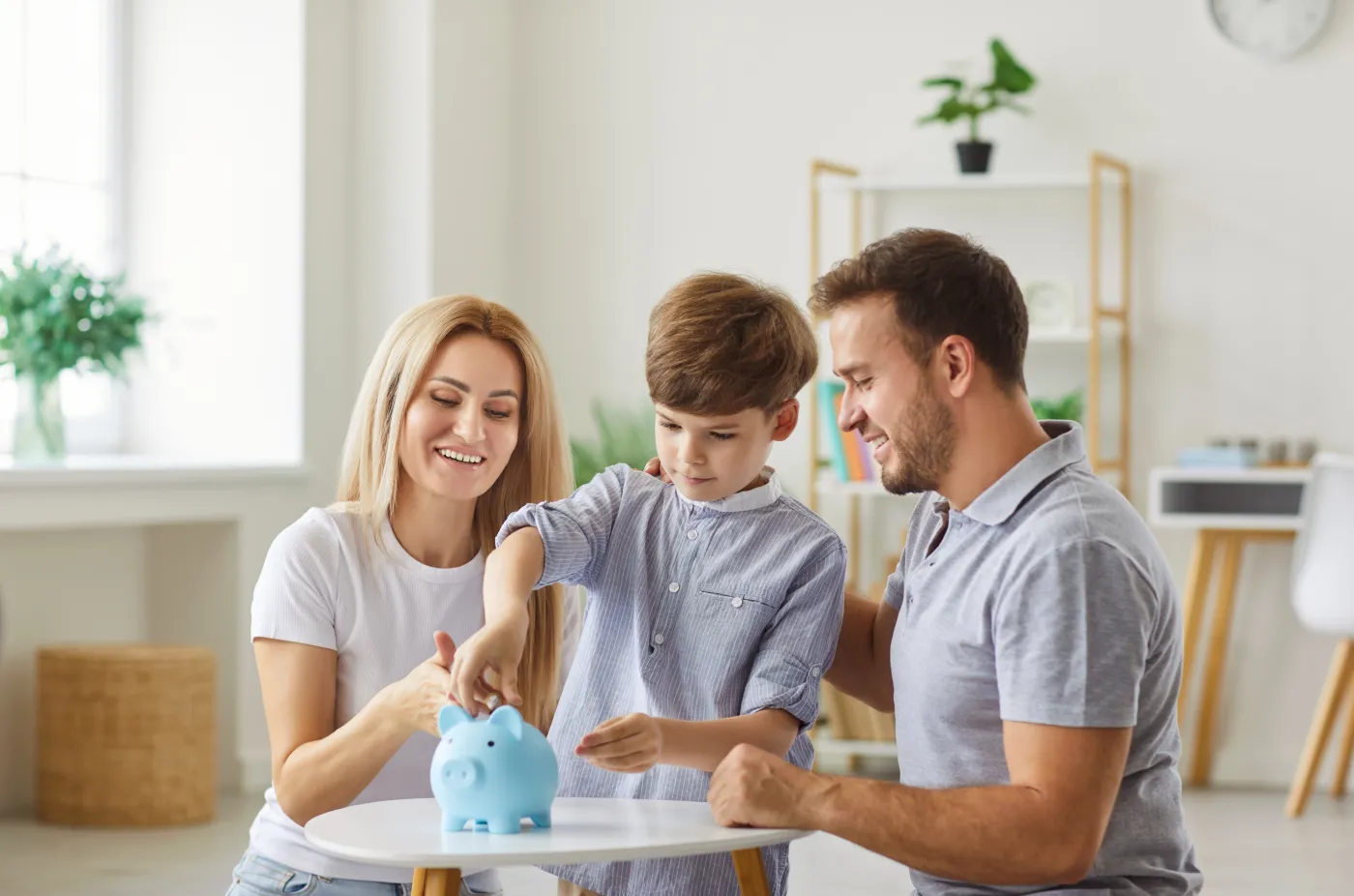 Parents,And,Child,Together,Put,A,Coin,Into,A,Piggy