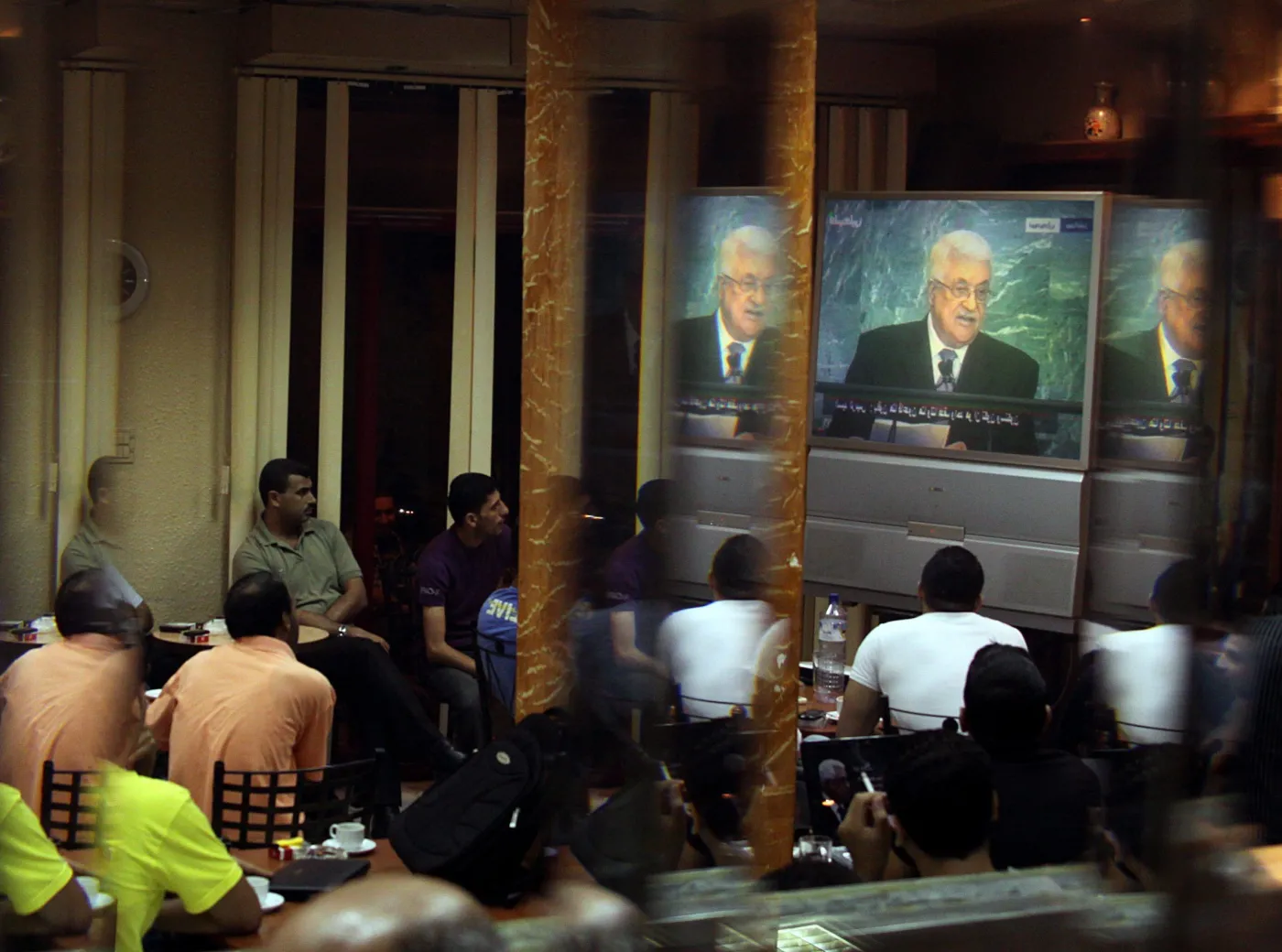 Palestyńczycy w kawiarni w Gazie słuchają przemówienia prezydenta Mahmouda Abbasa w ONZ 