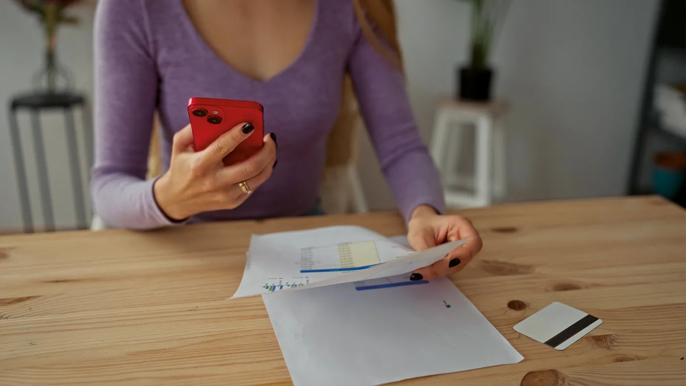 Kobieta trzyma telefon - Rzecznik Finansowy ostrzega przed oszustwem na nieaktywną kartę