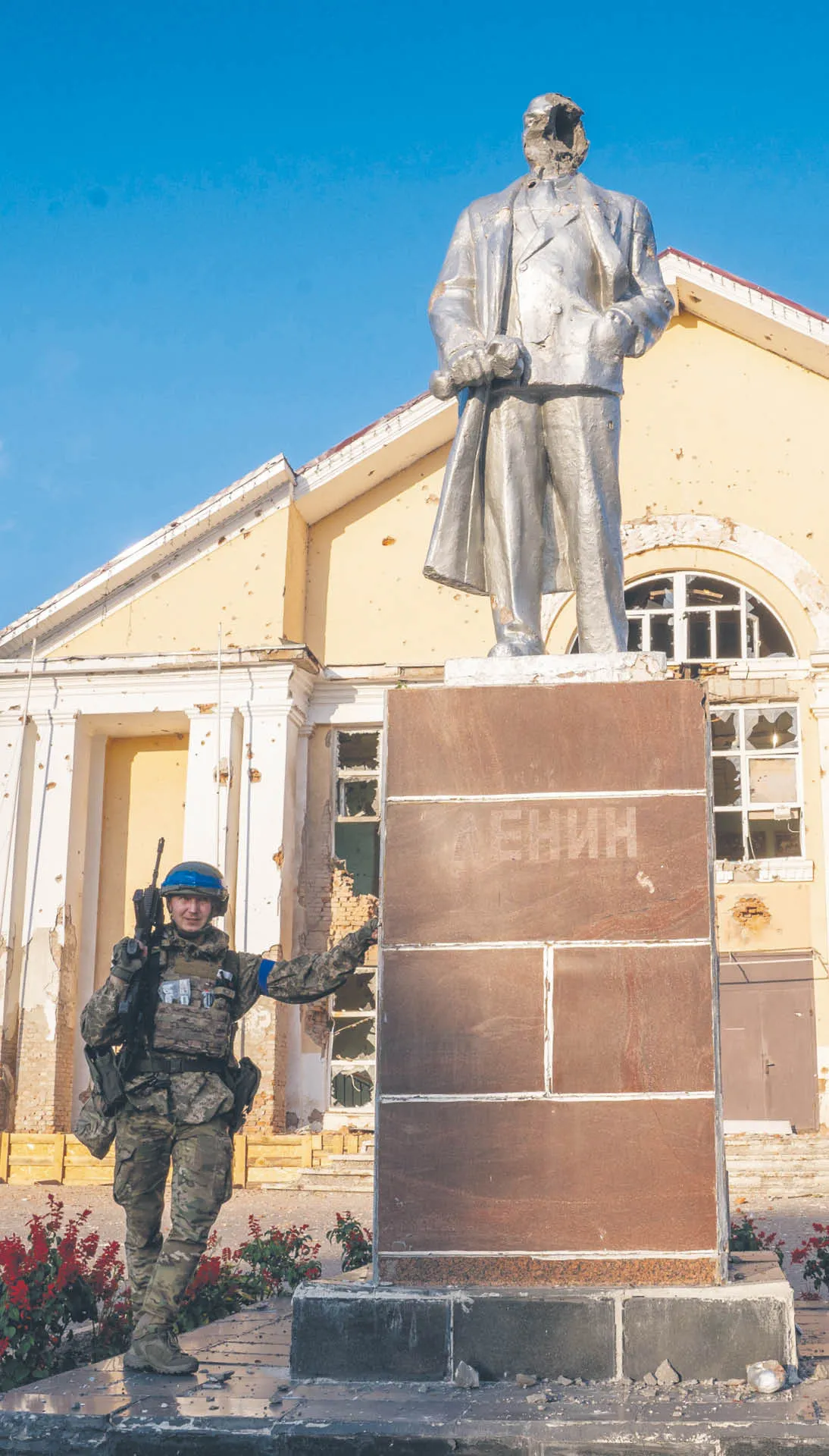 Ukraiński żołnierz przed pomnikiem Lenina po zajęciu miasta przez siły ukraińskie. Sudża w obwodzie kurskim, 16 sierpnia 2024 r.