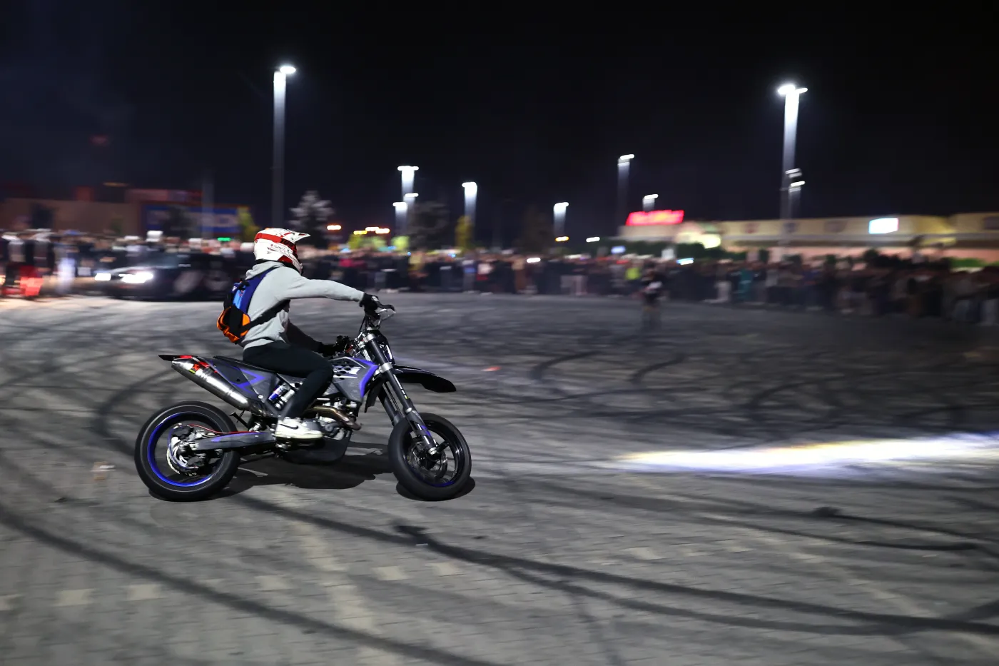 Motocykl gazujący na pustym parkingu nocą