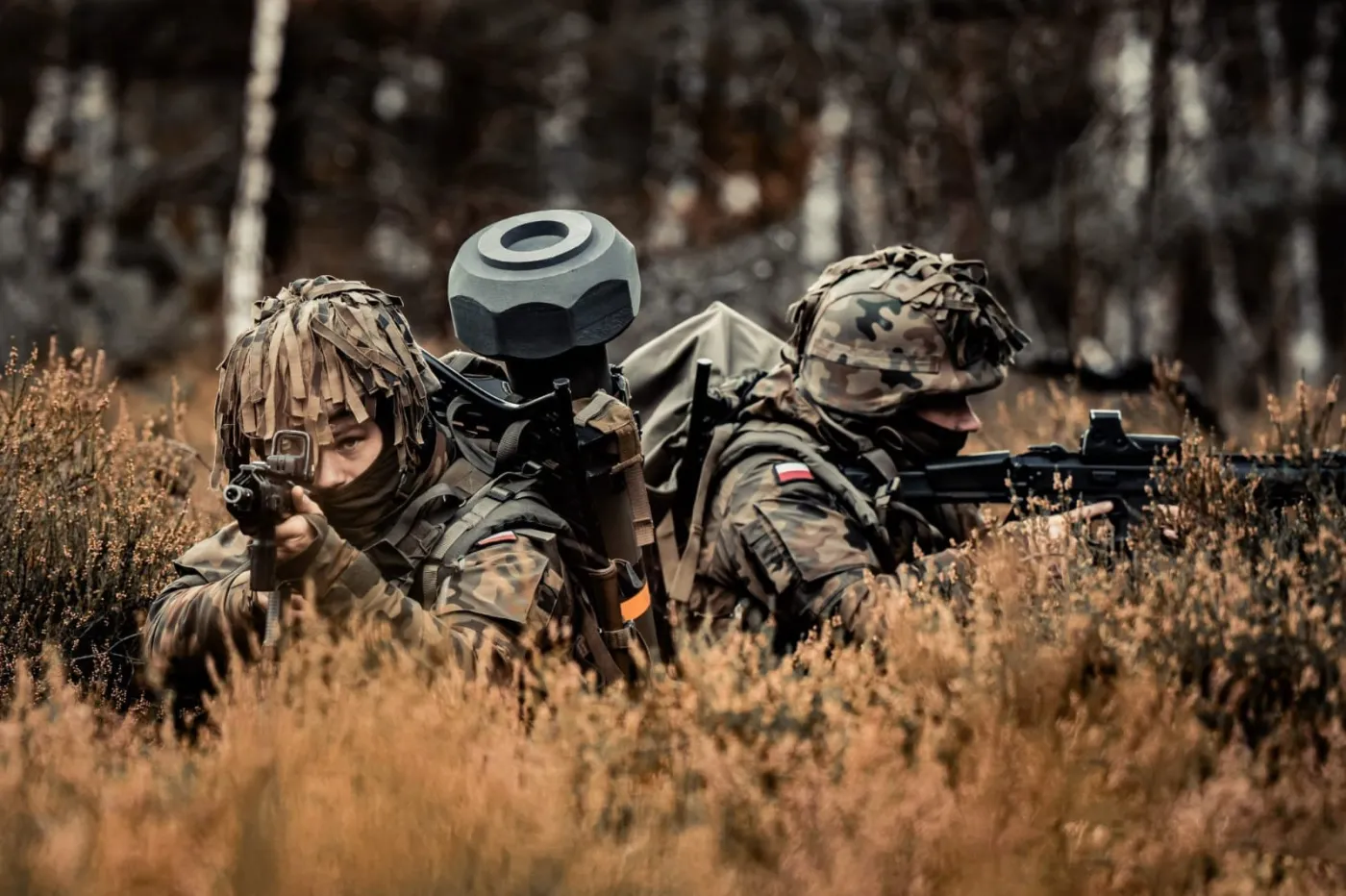 Dwaj żołnierze w trakcie szkolenia poligonowego. Na plecach dostrzec możemy kierowany pocisk przeciwpancerny Spike, a w rękach karabinki MSBS Grot. Widoczne na głowach hełmy kompozytowe to wz.2005.