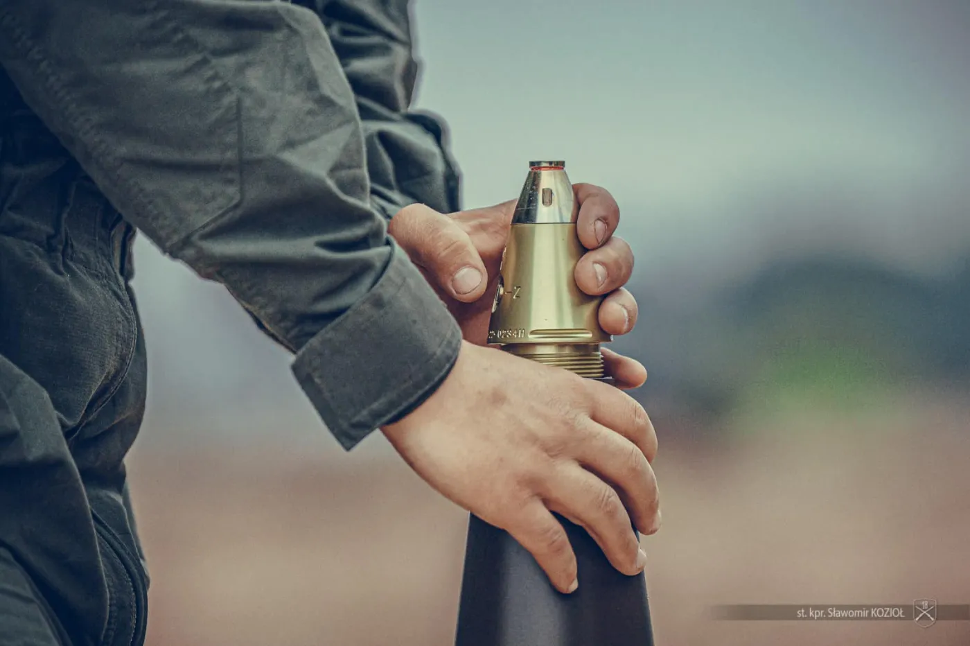 Polski żołnierz z 18 Dywizji Zmechanizowanej uzbraja nabój kalibru 155 mm przed strzelaniem z armatohaubic K9A1.