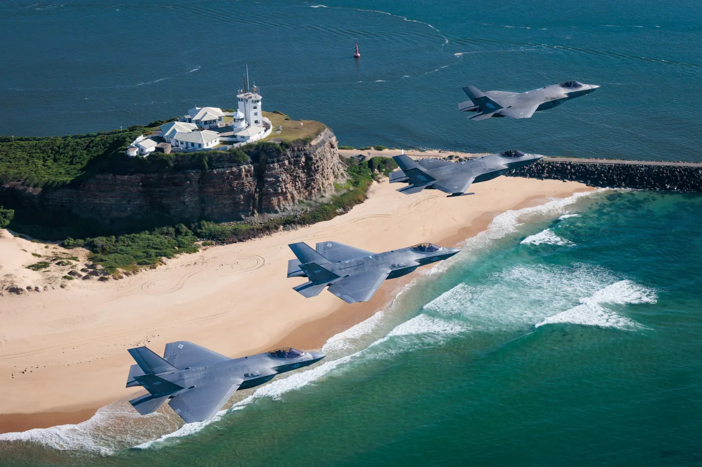 Dwa australijskie F-35A (od góry) oraz dwa amerykańskie F-35C w trakcie wspólnego lotu nad wybrzeżem Australii.