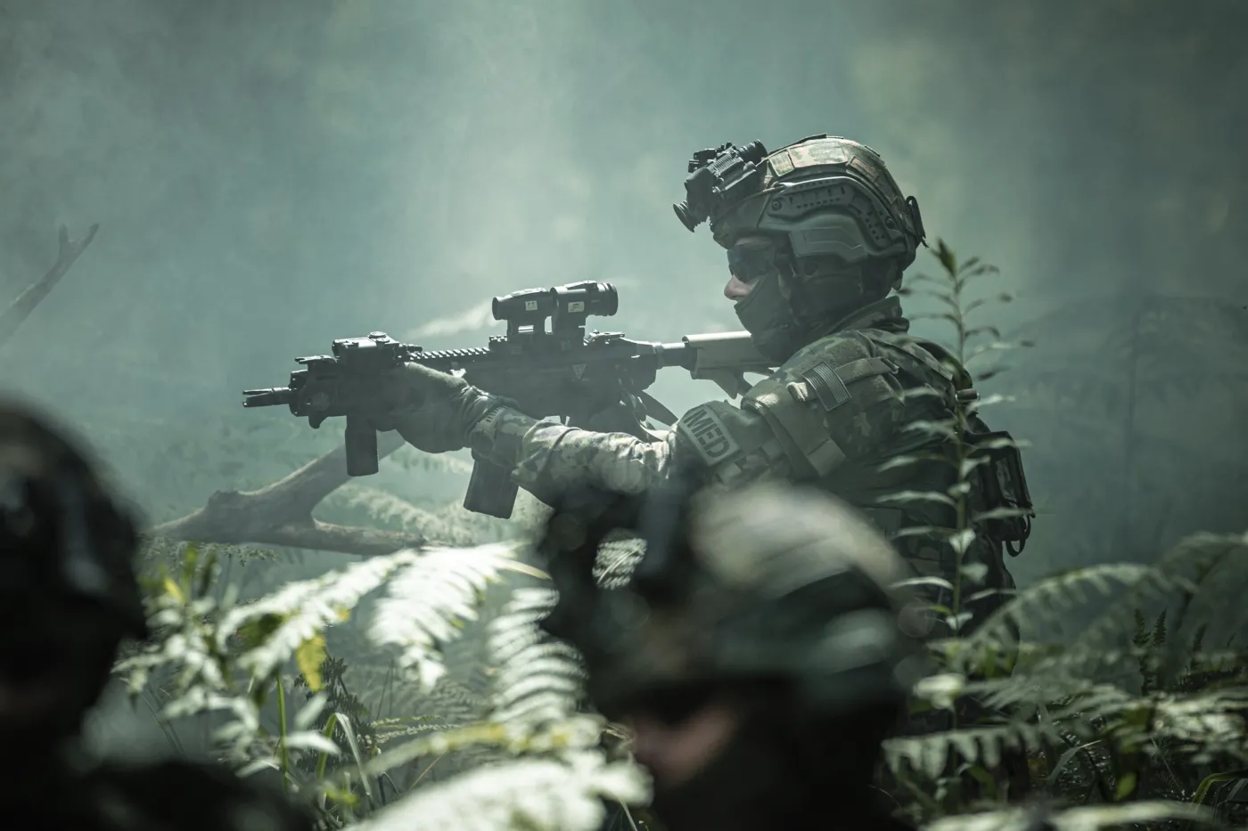 Fotografia przedstawiająca żołnierza ubranego w hełm HBT-02 oraz kazmielkę KBT-01. Dodatkowo na karabinku dostrzec możemy Celownik Kolimatorowy CK-3 i Powiększalnik Kolimatorowy PK-1.