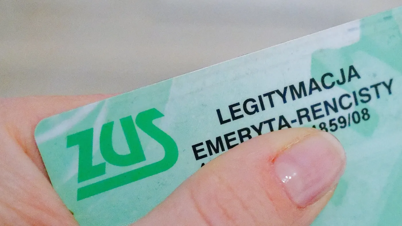 Legitymacja emeryta rencisty trzymana w palcach.