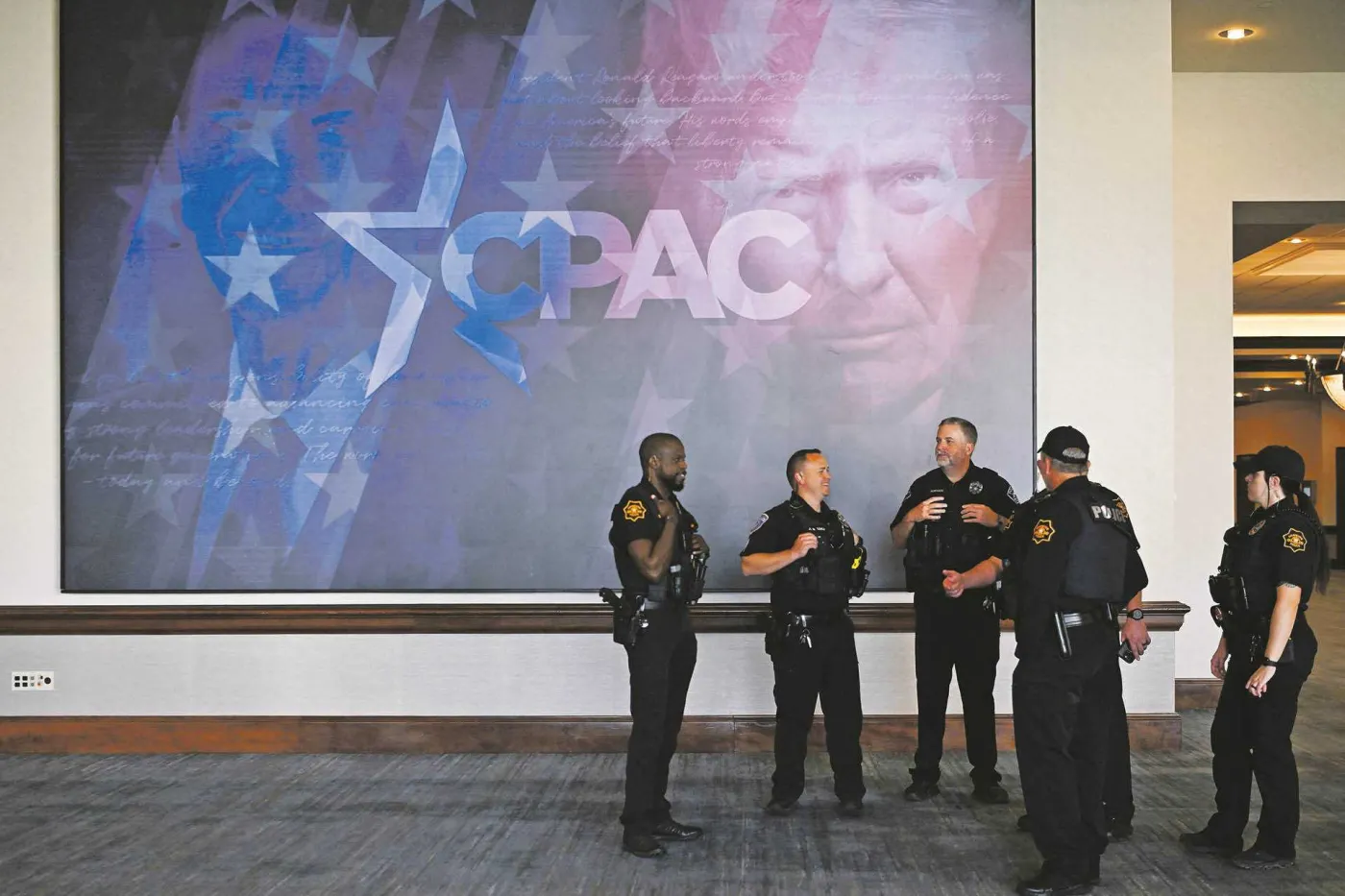 Policjancji na tle plakatu CPAC w Dallas