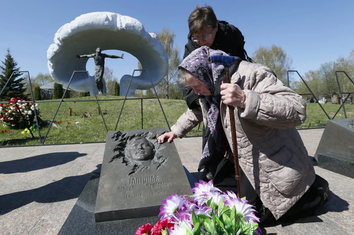 Matka jednego ze strażaków, którzy pomagali w Czarnobylu, na grobie syna. Fot. EPA/YURI KOCHETKOV/PAP/EPA