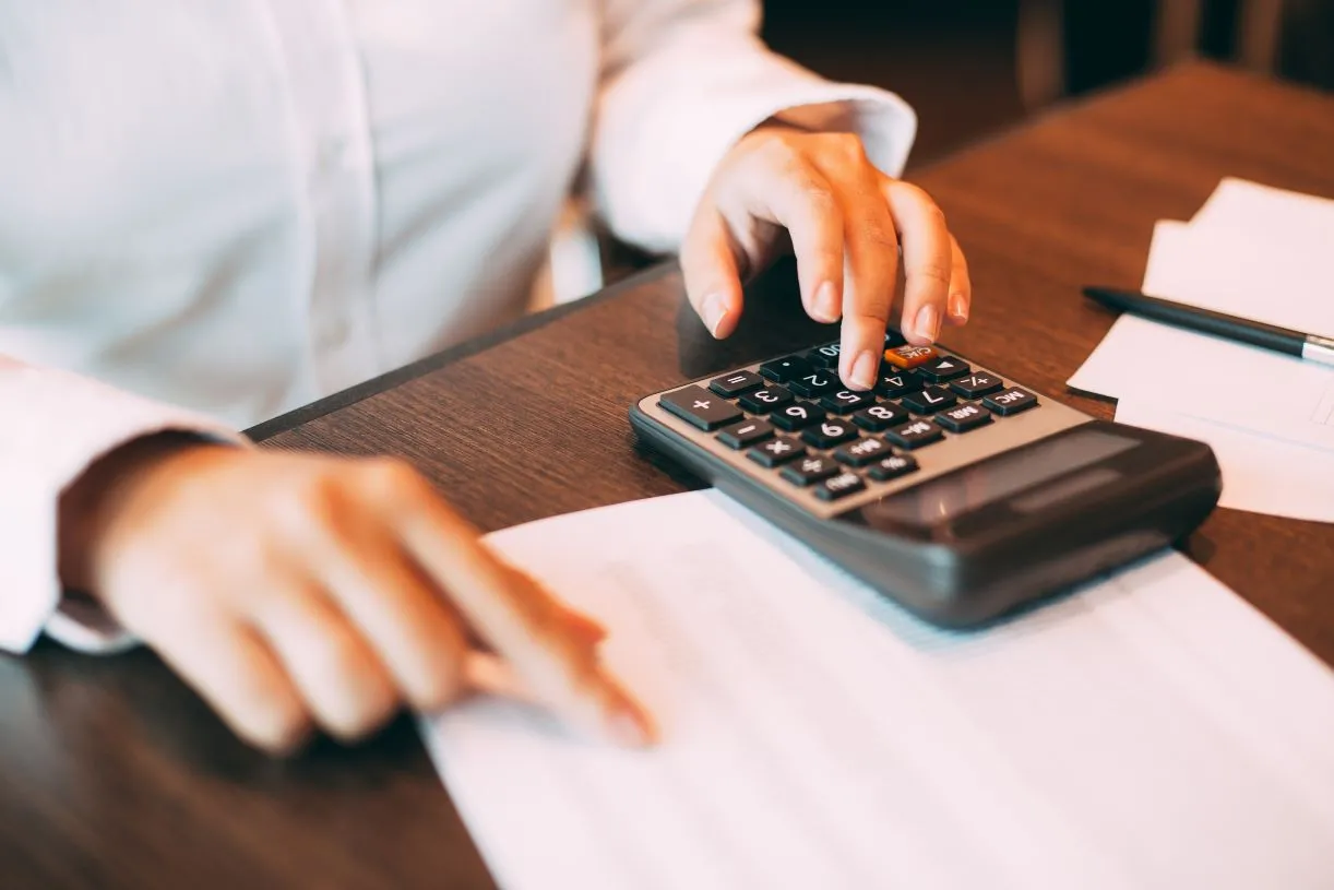 Mężczyzna z kalkulatorem robiący obliczenia