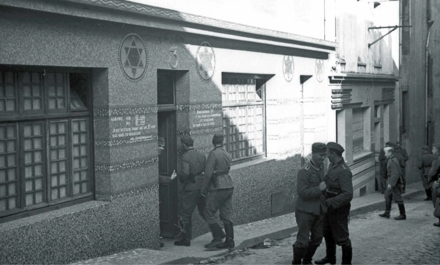 Czarno-biała fotografia przedstawia dom publiczny dla niemieckich żołnierzy urządzony w dawnej synagodze w Breście we Francji oraz mężczyzn stojących przed nim.