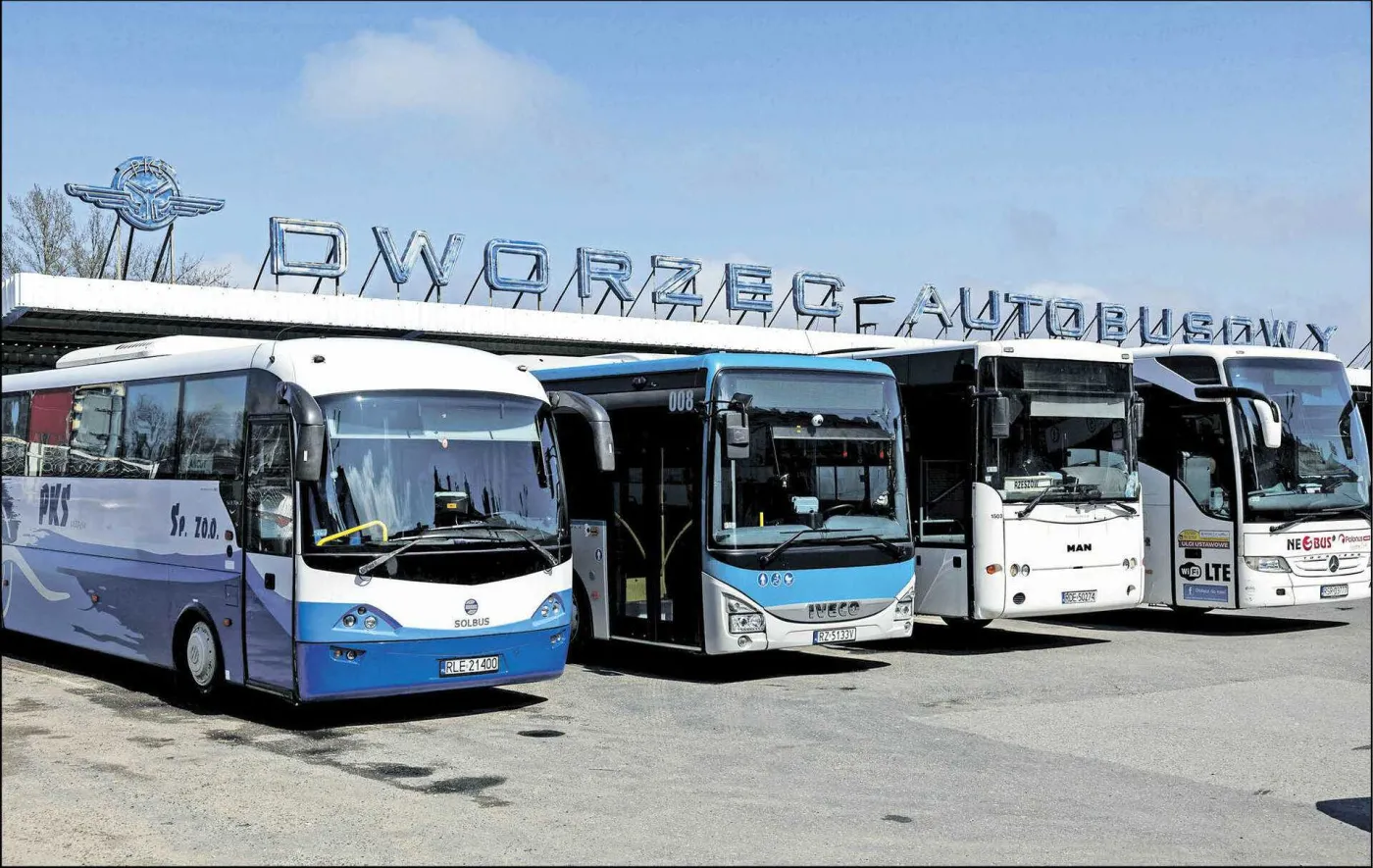 Miejski dworzec autobusowy z zaparkowanymi pojazdami.